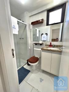 uma casa de banho com um WC, um chuveiro e um lavatório. em Apartamento completo e pé na areia no Rio Vermelho em Salvador