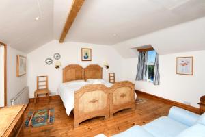 1 dormitorio con cama de madera y sofá en Craigadam, en Kirkpatrick Durham