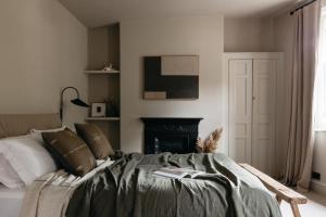 een slaapkamer met een bed en een open haard bij The Curator's Apartment - 2 Bedrooms with parking in Bath