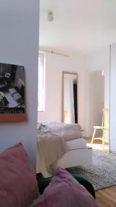 a white bedroom with a bed and a mirror at steenkampstudios GRANNS' SUITE in Hamburg