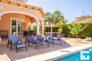 a patio with chairs and a swimming pool at Villa Coral - Grupo Turis in Calpe