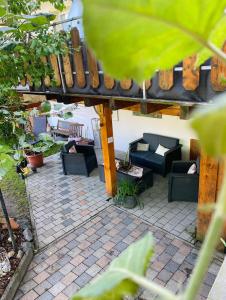 een patio met banken en stoelen op een bakstenen patio bij Ferienhof Neukirchinger in Tiefenbach
