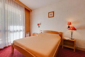 1 dormitorio con cama y ventana en Vacancéole - Résidence Cabourg en Mont-de-Lans