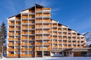 a large building with balconies in the snow at Vacancéole - Résidence Cabourg in Mont-de-Lans