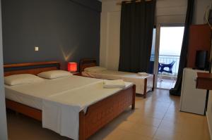 a hotel room with two beds and a balcony at La Maroja View Hotel in Dhërmi