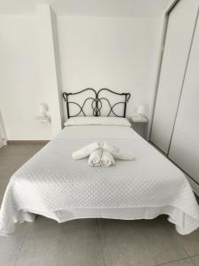 sypialnia z białym łóżkiem i 2 ręcznikami w obiekcie Apartamento Centro Ronda 2 w mieście Ronda