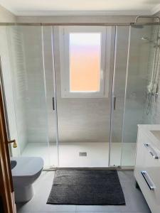 baño con ducha y aseo y ventana en Cabo Romano, 3 Bedroom,2 Bathroom Apartment with Sea Views LMHA 14, en La Manga del Mar Menor