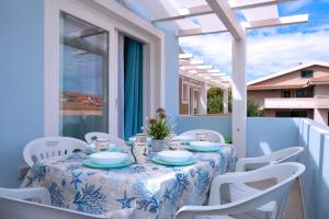 una mesa con un mantel azul y blanco en el balcón en Dòmo#15 - Villino con piscina, 8 min dal mare, en Viddalba