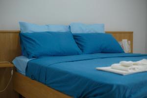 ein blaues Bett mit blauen Kissen und Handtüchern darauf in der Unterkunft Il Richiamo Del Mare in Neapel