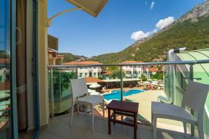 a balcony with a view of a pool and mountains at Belcehan Hotel in Oludeniz