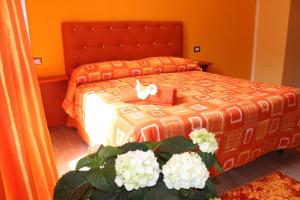 una camera da letto con un letto con fiori bianchi di B&B Fontevecchia a Castelsardo