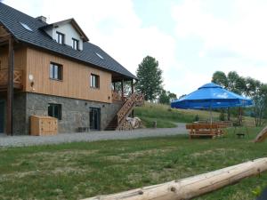 una casa con una sombrilla azul y una mesa en Dom z Zielonego Wzgórza 