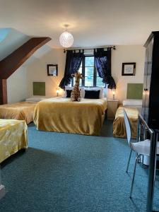 Habitación de hotel con 2 camas y una jirafa sentada en la cama en The Crown Lodge & Restaurant, en Dogdyke
