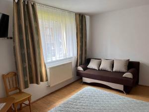 - un salon avec un canapé et une fenêtre dans l'établissement Oskolok Dovbusha Mini-Hotel, à Yaremtche