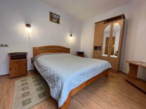 una camera da letto con un letto grande e uno specchio di Oskolok Dovbusha Mini-Hotel a Jaremče