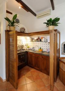 uma cozinha com armários de madeira e dois vasos de plantas em Villa Oliver - Breathtaking small Pool 14 sqm Hydromassage on the Rock - Amalfi Coast em Amalfi