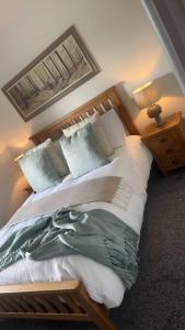 a bedroom with a large bed with white sheets and pillows at Tosside Fold Farm Cottage in Skipton