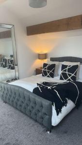 a bedroom with a large bed with a large mirror at Tosside Fold Farm Cottage in Skipton
