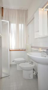 ein weißes Badezimmer mit 2 Waschbecken und einem WC in der Unterkunft Residence Ranieri in Bibione