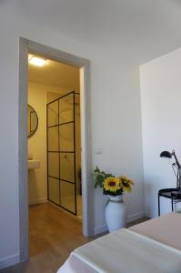 Un dormitorio con un jarrón con flores. en Club Tropicana Boutique Apartments en San Felice Circeo