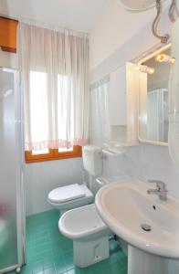 ein weißes Bad mit einem WC und einem Waschbecken in der Unterkunft Residence Ranieri in Bibione