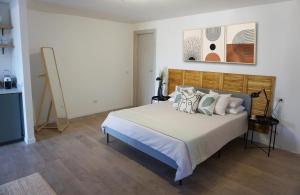 una camera da letto con un grande letto con cuscini sopra di Club Tropicana Boutique Apartments a San Felice Circeo