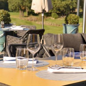a group of wine glasses sitting on a table at Hôtel Golf & Spa Château de la Bégude The Originals Collection in Valbonne