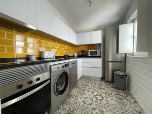 a kitchen with a washing machine in a kitchen at Casa da Travessa in Évora