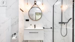 a white bathroom with a sink and a mirror at Flatbook - City Center SPA Apartments Toruńska 11 in Gdańsk