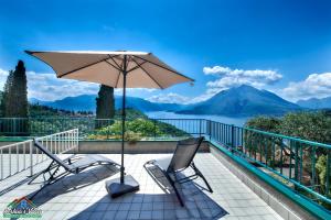un patio con 2 sillas y una sombrilla en Sunset app - Lake Como View, en Perledo