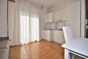 eine Küche mit weißen Schränken und einem großen Fenster in der Unterkunft Residence Ranieri in Bibione