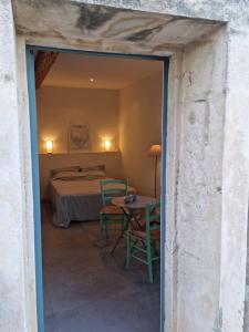 a bedroom with a bed and a table and chairs at Gîtes de l'Estagnol in Villeneuve-lès-Maguelonne