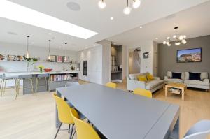 a kitchen and living room with a table and chairs at Wonderful family home with garden near Twickenham by UnderTheDoormat in London