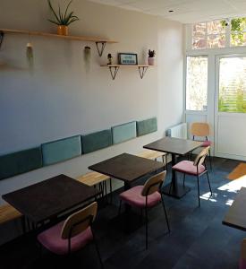 une salle à manger avec des tables et des chaises roses dans l'établissement Hôtel de France, à Pléneuf-Val-André