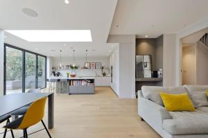 a living room and kitchen with a couch and a table at Wonderful family home with garden near Twickenham by UnderTheDoormat in London