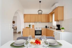 a kitchen with a table with plates and wine glasses at Orkos Naxian Wave 3 in Mikri Vigla