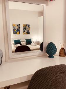 Kanisa Mari e Monti في شينيسي: غرفة نوم مع مرآة كبيرة على الحائط