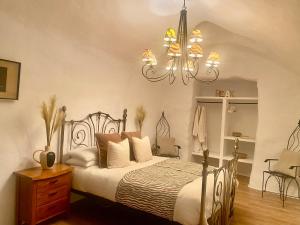 1 dormitorio con cama y lámpara de araña en Cuevas Helena, en Benamaurel