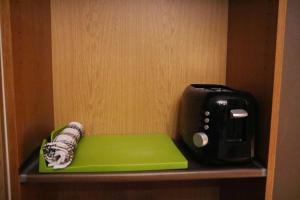 una tostadora sentada en un estante junto a un cuaderno verde en Modern Private Studio Room en Londres