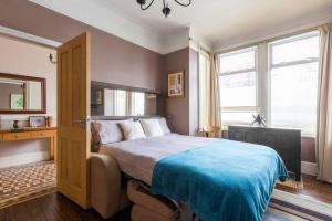 een slaapkamer met een groot bed en een blauwe deken bij Modern Private Studio Room in Londen