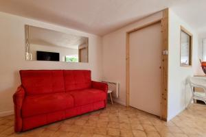 a red couch in a living room with a sliding door at Dolce Apartment 3 Bedrooms for 5 people 10 minutes from Cannes in Mandelieu-la-Napoule