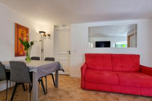 Dolce Apartment 3 Bedrooms for 5 people 10 minutes from Cannes في ماندوليو لا نابول: غرفة معيشة مع أريكة حمراء وطاولة