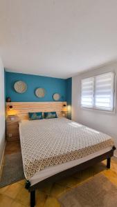 een slaapkamer met een groot bed met een blauwe muur bij Dolce Apartment 3 Bedrooms for 5 people 10 minutes from Cannes in Mandelieu-la-Napoule