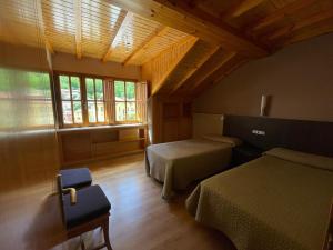 sypialnia z 2 łóżkami i oknem w obiekcie PENSION CASA MIÑO w mieście Pola de Somiedo