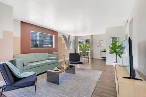 a living room with a couch and a tv at Roami at The Palm in Fort Lauderdale