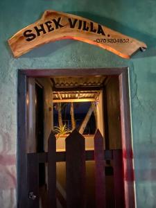 eine Tür mit einem Schild an der Seite eines Gebäudes in der Unterkunft Shek villa in Hikkaduwa