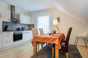 een keuken en eetkamer met een tafel en stoelen bij Haus Barbara, Ferienwohnung, 90qm in Unterreitnau