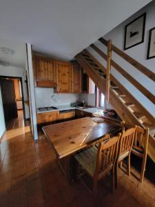 uma cozinha com uma mesa de madeira e uma escada em La casa lassù em Tarvisio