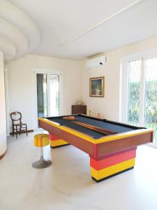 una sala de billar con mesa de billar y taburete en Rho Mind Villa, en Rho
