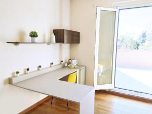 a white kitchen with a shelf and a window at Rho Mind Villa in Rho
